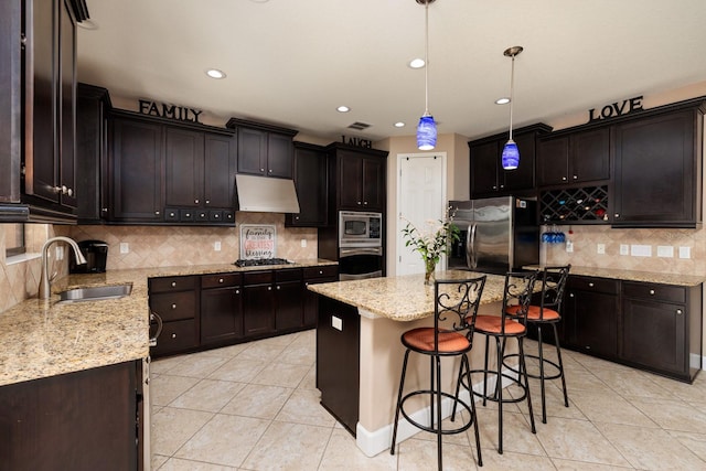 4611 Grand Preserve Pl, Palm Harbor, FL 34684 - kitchen with appliances with stainless steel finishes, a sink, under cabinet range hood, light tile patterned floors, and a kitchen island