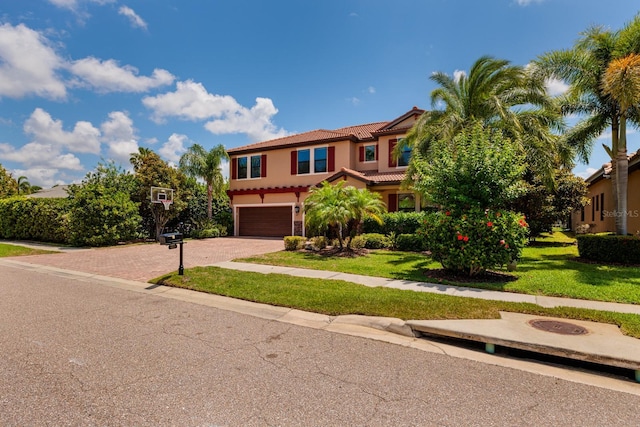 4611 Grand Preserve Pl, Palm Harbor, FL 34684 - mediterranean / spanish home with stucco siding, a tiled roof, decorative driveway, a garage, and a front lawn