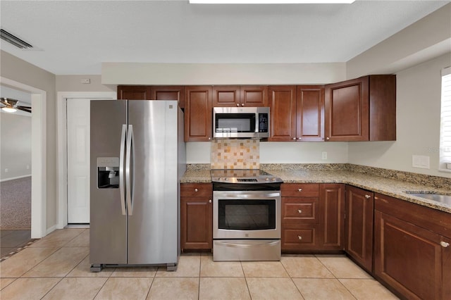 204 Cove Ct, Clearwater, FL 33756 - kitchen featuring stainless steel appliances, light tile patterned floors, light stone countertops, and a ceiling fan