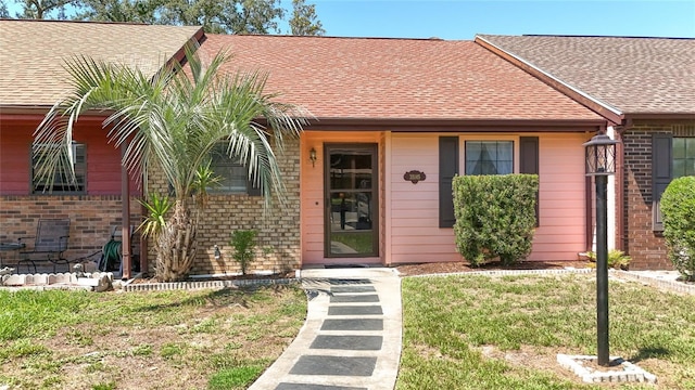 35145 Whispering Oaks Blvd, Dade City, FL 33523 - view of front facade with brick siding, a shingled roof, and a front yard