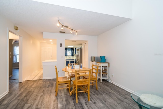 35145 Whispering Oaks Blvd, Dade City, FL 33523 - dining space featuring wood finished floors, baseboards, a textured ceiling, and track lighting