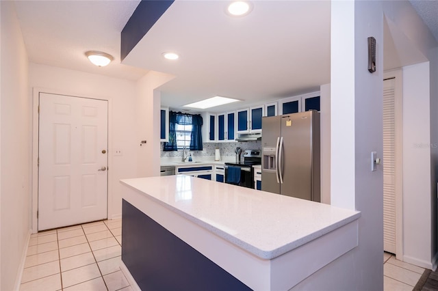 35145 Whispering Oaks Blvd, Dade City, FL 33523 - kitchen featuring appliances with stainless steel finishes, exhaust hood, light tile patterned floors, blue cabinets, and recessed lighting