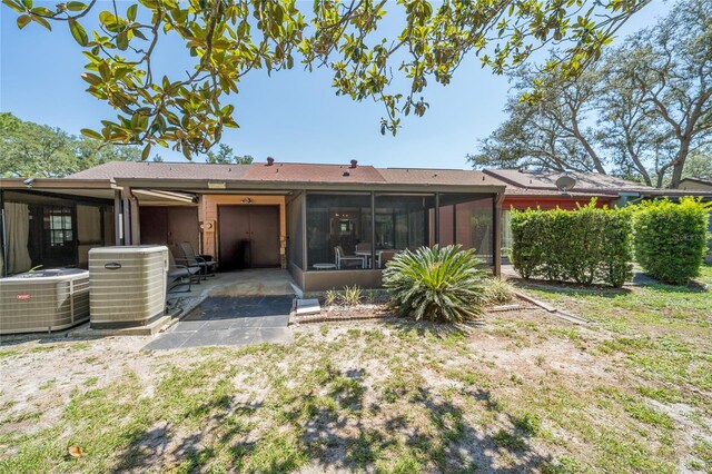 35145 Whispering Oaks Blvd, Dade City, FL 33523 - back of house with central AC unit, a patio area, and a sunroom