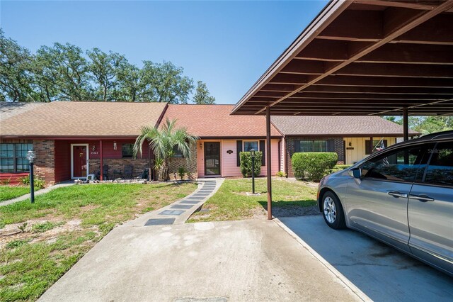 35145 Whispering Oaks Blvd, Dade City, FL 33523 - view of front of home featuring brick siding, a front lawn, and a shingled roof
