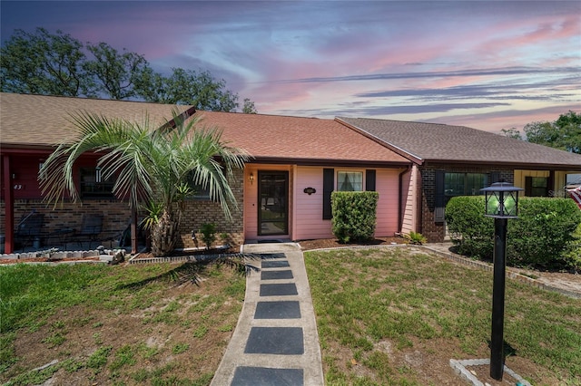 35145 Whispering Oaks Blvd, Dade City, FL 33523 - ranch-style home featuring brick siding, a front lawn, and a shingled roof