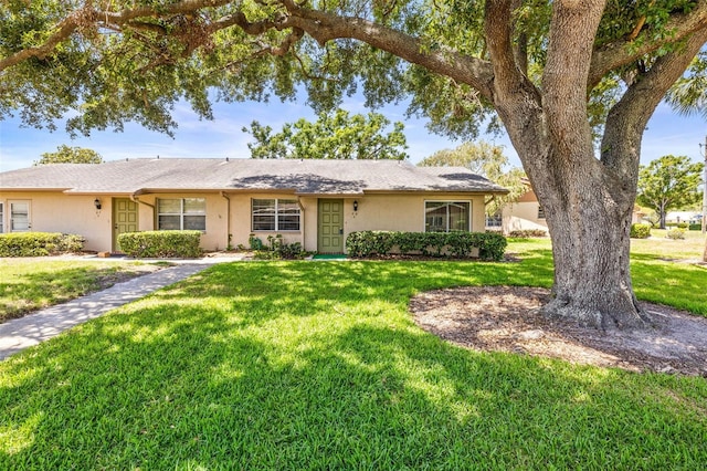 single story home with stucco siding and a front yard