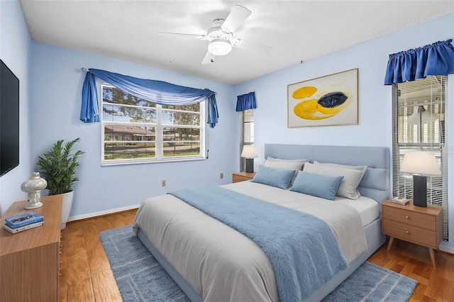 bedroom with wood finished floors, a ceiling fan, and baseboards