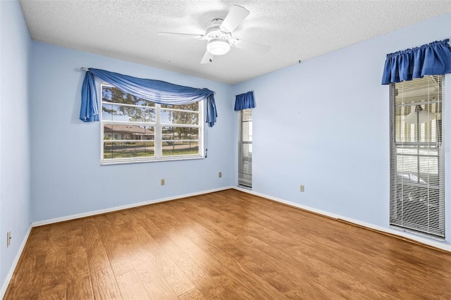 unfurnished room featuring wood finished floors, a textured ceiling, ceiling fan, and baseboards