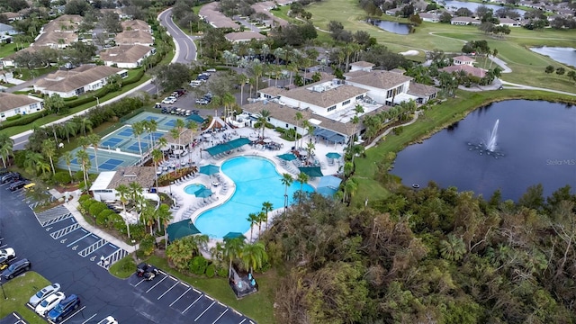 aerial overview of property's location featuring a large body of water, a pool, a local golf course, and nearby suburban area