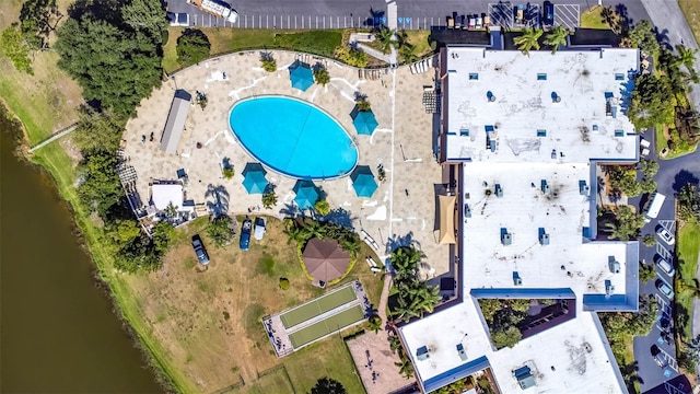 aerial view of property and surrounding area with a pool area and a large body of water