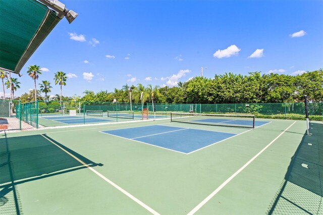 view of tennis court with fence and community basketball court