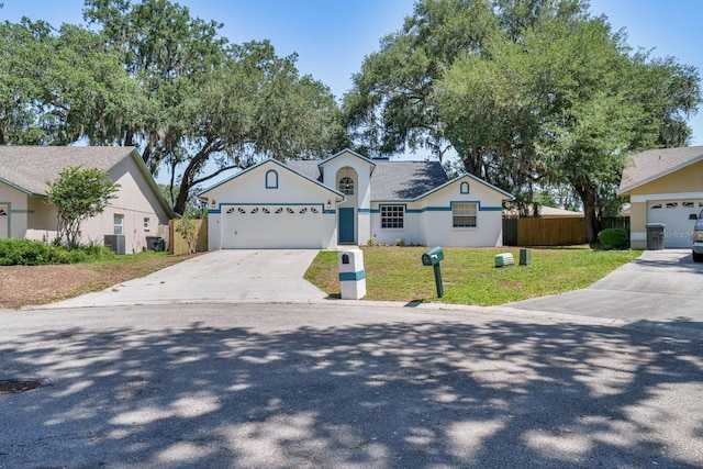 748 Sagewood Dr, Lakeland, FL 33813 - view of front of home with driveway, an attached garage, central AC, and stucco siding