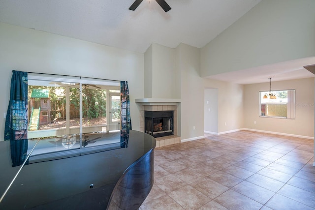 748 Sagewood Dr, Lakeland, FL 33813 - unfurnished living room featuring a ceiling fan, high vaulted ceiling, a fireplace, tile patterned flooring, and baseboards