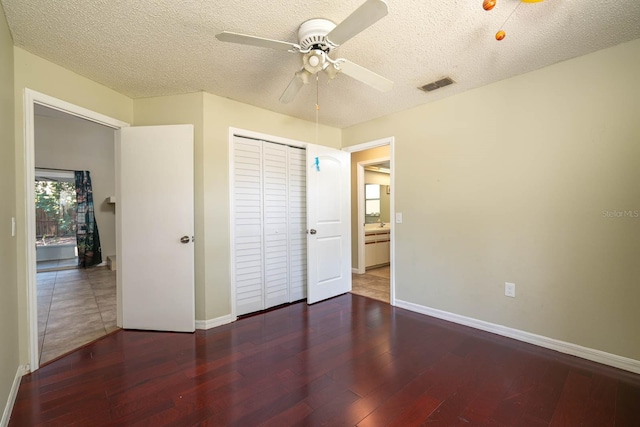 748 Sagewood Dr, Lakeland, FL 33813 - unfurnished bedroom with wood finished floors, a textured ceiling, baseboards, a closet, and a ceiling fan
