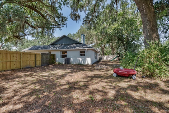 748 Sagewood Dr, Lakeland, FL 33813 - rear view of house with a playground, fence, cooling unit, and a chimney