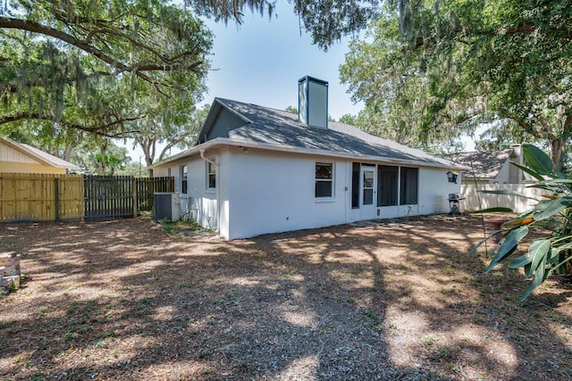 748 Sagewood Dr, Lakeland, FL 33813 - back of property featuring a fenced backyard, a chimney, and central air condition unit