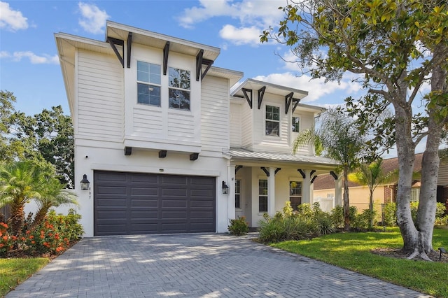 807 W Kentucky Ave, Tampa, FL 33603 - view of front facade with an attached garage, a standing seam roof, metal roof, decorative driveway, and stucco siding