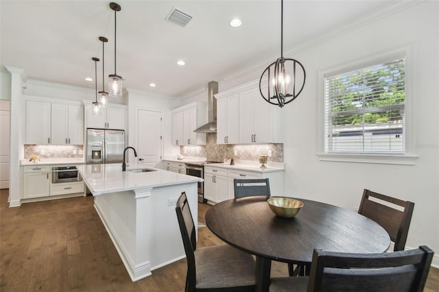 807 W Kentucky Ave, Tampa, FL 33603 - kitchen with stainless steel appliances, wall chimney exhaust hood, tasteful backsplash, a sink, and light countertops