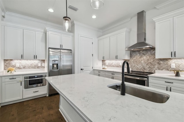807 W Kentucky Ave, Tampa, FL 33603 - kitchen with wall chimney exhaust hood, stainless steel appliances, backsplash, white cabinetry, and pendant lighting