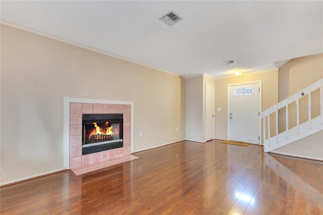 728 Waterbridge Dr, Winter Haven, FL 33880 - unfurnished living room featuring wood finished floors, stairway, a tile fireplace, and ornamental molding
