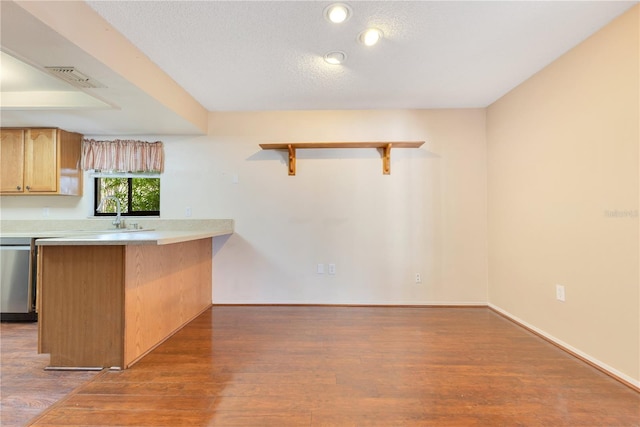 728 Waterbridge Dr, Winter Haven, FL 33880 - kitchen with stainless steel dishwasher, wood finished floors, open shelves, light countertops, and a peninsula