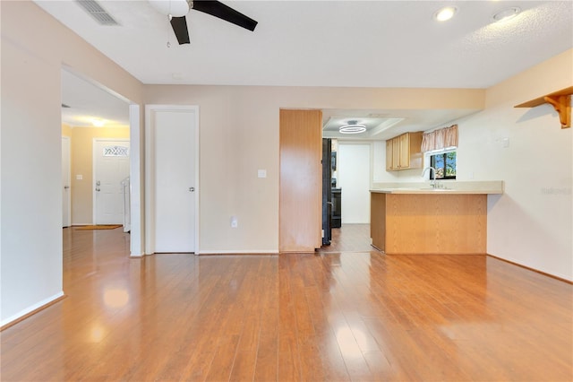728 Waterbridge Dr, Winter Haven, FL 33880 - unfurnished living room featuring a sink, ceiling fan, light wood-type flooring, and baseboards