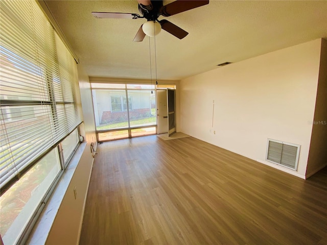 4351 Tahitian Gardens Cir Unit H, Holiday, FL 34691 - empty room with wood finished floors, ceiling fan, and a textured ceiling