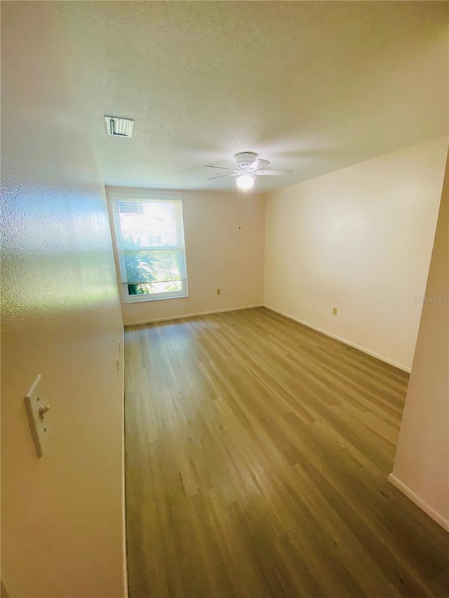 4351 Tahitian Gardens Cir Unit H, Holiday, FL 34691 - spare room with wood finished floors, ceiling fan, baseboards, and a textured ceiling