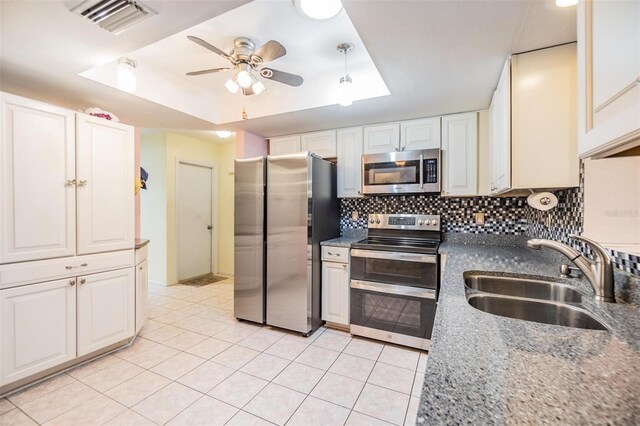 2308 Rio Cir, Spring Hill, FL 34608 - kitchen featuring stainless steel appliances, a sink, a tray ceiling, ceiling fan, and backsplash