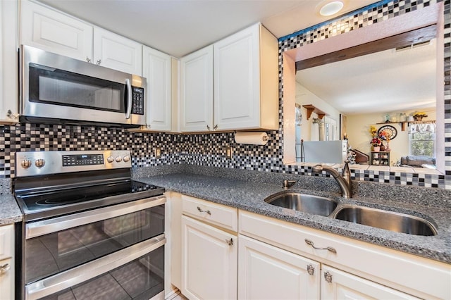 2308 Rio Cir, Spring Hill, FL 34608 - kitchen featuring stainless steel appliances, a sink, backsplash, and white cabinetry