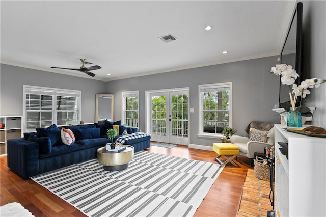 living room with crown molding, french doors, light wood-style flooring, a ceiling fan, and recessed lighting