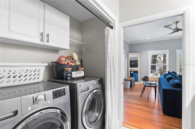 washroom featuring independent washer and dryer, wood finished floors, ornamental molding, and cabinet space
