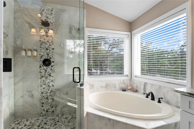 bathroom featuring a bath, a stall shower, healthy amount of natural light, and lofted ceiling