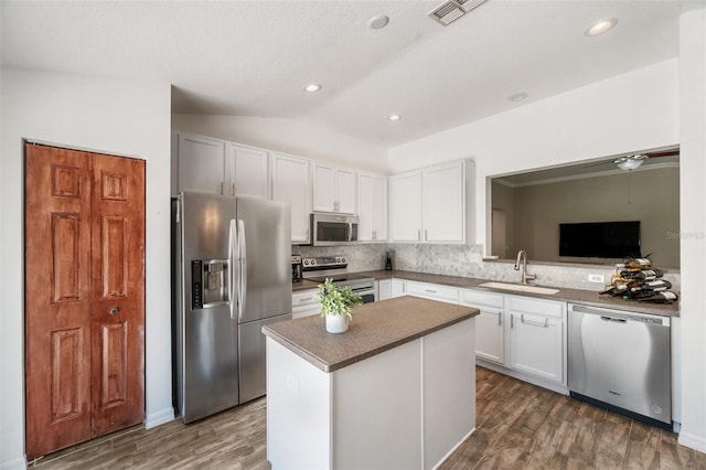 7103 Bridgeview Dr, Wesley Chapel, FL 33545 - kitchen featuring stainless steel appliances, backsplash, vaulted ceiling, a sink, and dark wood-type flooring