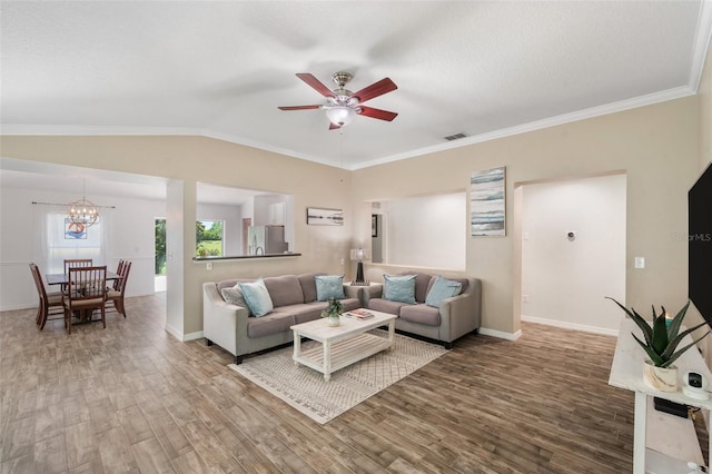 7103 Bridgeview Dr, Wesley Chapel, FL 33545 - living room featuring wood finished floors, ceiling fan, a chandelier, baseboards, and crown molding