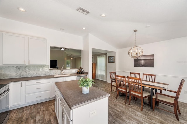 7103 Bridgeview Dr, Wesley Chapel, FL 33545 - kitchen featuring lofted ceiling, a sink, dark wood-type flooring, white cabinets, and recessed lighting