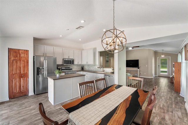 7103 Bridgeview Dr, Wesley Chapel, FL 33545 - dining room with vaulted ceiling, a chandelier, baseboards, wood finished floors, and recessed lighting
