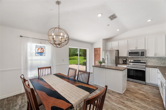 7103 Bridgeview Dr, Wesley Chapel, FL 33545 - dining room with a chandelier, vaulted ceiling, wood finished floors, and recessed lighting