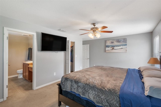 7103 Bridgeview Dr, Wesley Chapel, FL 33545 - bedroom featuring light carpet, connected bathroom, baseboards, ceiling fan, and a closet