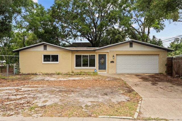 701 59th Ave NE, Saint Petersburg, FL 33703 - ranch-style home featuring fence, concrete driveway, a garage, and brick siding