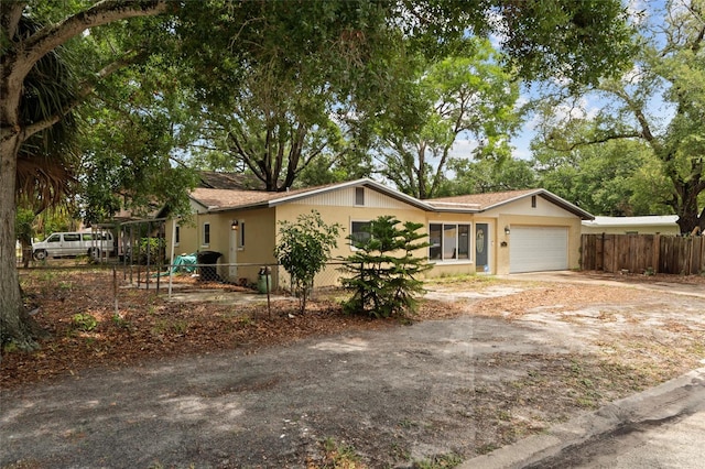 701 59th Ave NE, Saint Petersburg, FL 33703 - ranch-style home with fence, a garage, and dirt driveway
