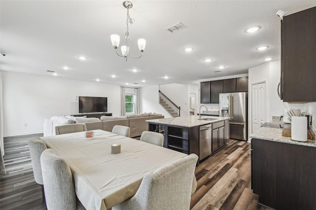 14282 Coronado Dr, Spring Hill, FL 34609 - dining room featuring dark wood finished floors, recessed lighting, stairs, and a chandelier