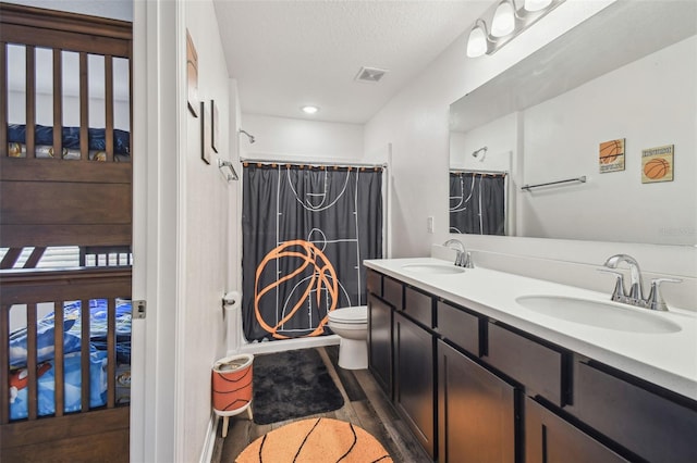 14282 Coronado Dr, Spring Hill, FL 34609 - full bathroom featuring toilet, wood finished floors, double vanity, curtained shower, and a textured ceiling