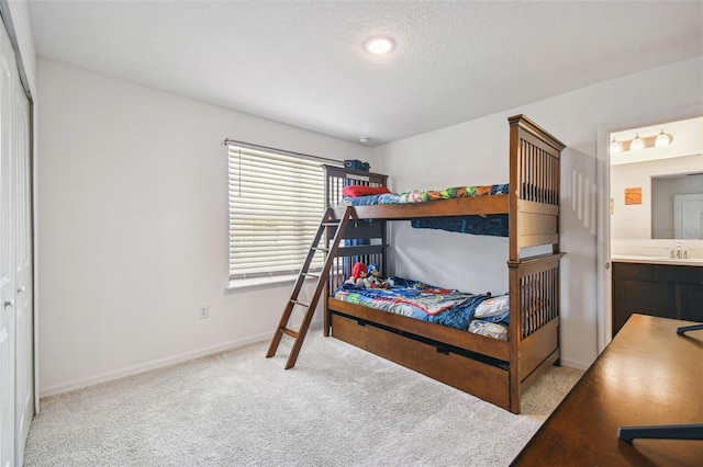 14282 Coronado Dr, Spring Hill, FL 34609 - carpeted bedroom featuring a sink, baseboards, connected bathroom, and a textured ceiling