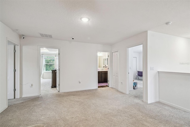 14282 Coronado Dr, Spring Hill, FL 34609 - spare room featuring light colored carpet, baseboards, and a textured ceiling