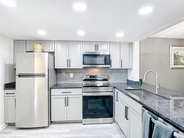 14130 Rosemary Ln Unit 3215, Largo, FL 33774 - kitchen with appliances with stainless steel finishes, a sink, dark stone counters, tasteful backsplash, and recessed lighting