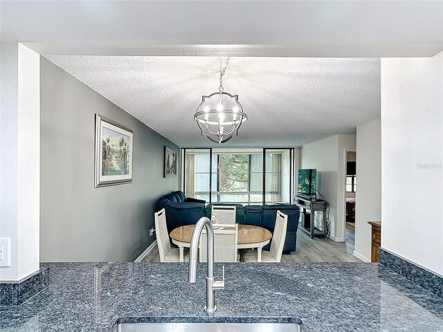 14130 Rosemary Ln Unit 3215, Largo, FL 33774 - dining area featuring a textured ceiling, a chandelier, and wood finished floors