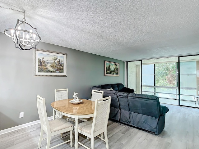 14130 Rosemary Ln Unit 3215, Largo, FL 33774 - dining room featuring a textured ceiling, a chandelier, light wood-style floors, floor to ceiling windows, and baseboards