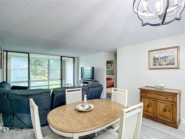 14130 Rosemary Ln Unit 3215, Largo, FL 33774 - dining area with a chandelier, a textured ceiling, and light wood-style floors