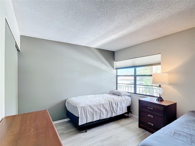 14130 Rosemary Ln Unit 3215, Largo, FL 33774 - bedroom featuring light wood-type flooring, a textured ceiling, and baseboards